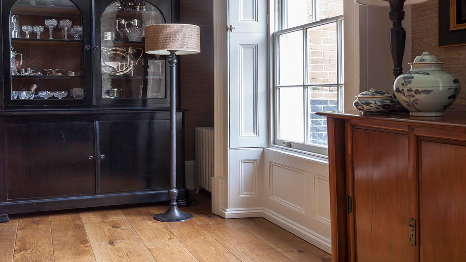 Well lit Oak flooring with a floor lamp